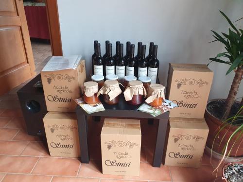 un grupo de botellas de vino y cajas sobre una mesa en Azienda Agricola Sinisi, en Cerveteri