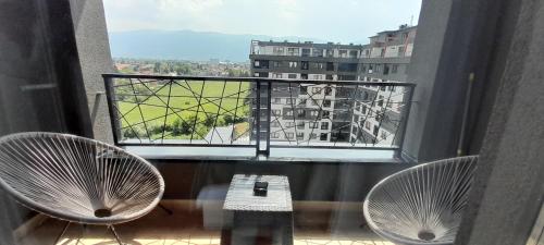 a balcony with two chairs and a view of a building at Delux Apartmani Bulevar in Sarajevo