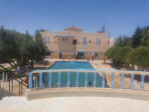 ein Haus mit einem Pool vor einem Gebäude in der Unterkunft Hotel complex europe in Guercif