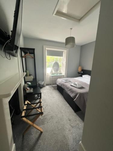 a bedroom with a bed, chair and a window at Antrobus Hotel in Amesbury