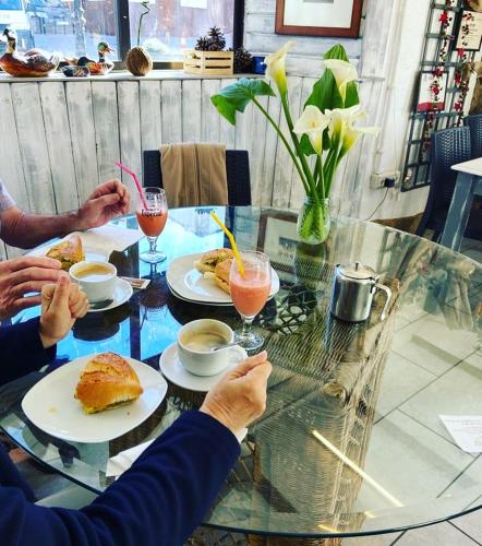 two people sitting at a glass table with food at Casa Cueva El Molino By Artenatur in Artenara