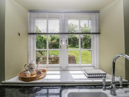 a kitchen window with a sink and a counter at Redwood Cottage in Bristol