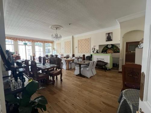 a living room with tables and chairs in a room at Antrobus Hotel in Amesbury