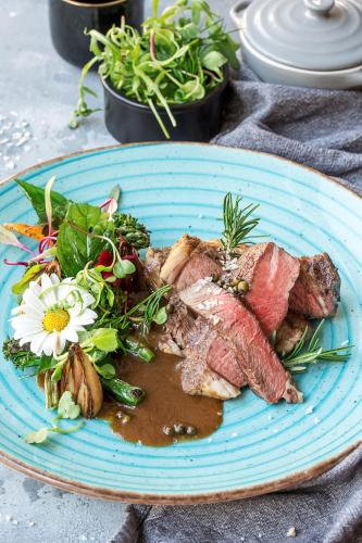 a blue plate of food with meat and a salad at Radisson Blu Hotel Wroclaw in Wrocław
