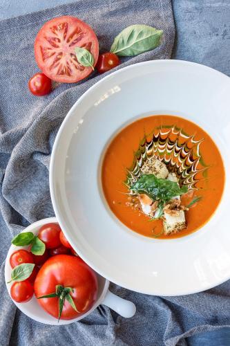 a bowl of tomato soup with a bowl of tomatoes at Radisson Blu Hotel Wroclaw in Wrocław