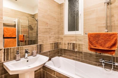 La salle de bains est pourvue d'un lavabo et d'une baignoire. dans l'établissement BOX Studio in Ruin Pub District, à Budapest