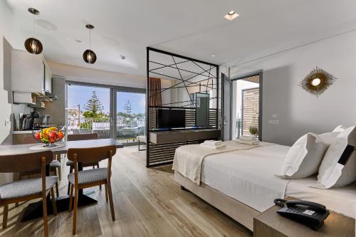 a bedroom with a bed and a table and a kitchen at Seascape Luxury Residences in Agia Pelagia