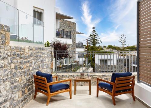 a patio with two chairs and a table at Seascape Luxury Residences in Agia Pelagia