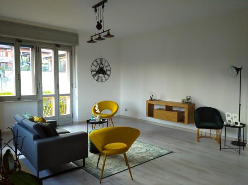 een woonkamer met een blauwe bank en gele stoelen bij ALLA DAMIGIANA in SantʼAmbrogio di Torino