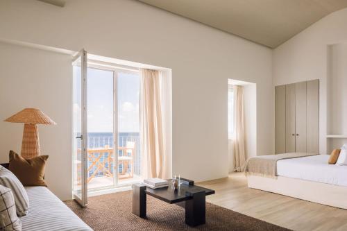 a bedroom with a bed and a view of the ocean at White Exclusive Suites & Villas in Lagoa