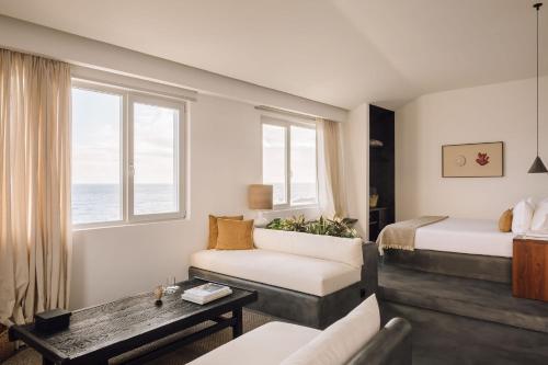 a hotel room with a bed and a couch and a table at White Exclusive Suites & Villas in Lagoa