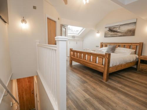 a bedroom with a large bed and a staircase at Oak Cottage in Windermere