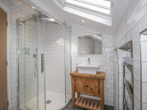 a bathroom with a sink and a shower and a tub at Oak Cottage in Windermere