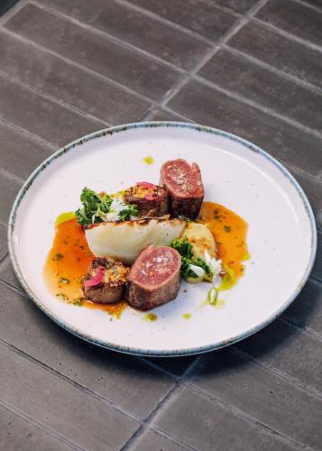 a plate of food with meat on a table at White Exclusive Suites & Villas in Lagoa