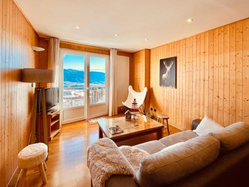a living room with a couch and a table at 1966 Appartement Cosy à Font Romeu parking couvert in Font Romeu Odeillo Via