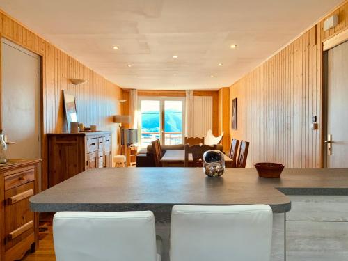 a kitchen with a table and chairs and a living room at 1966 Appartement Cosy à Font Romeu parking couvert in Font Romeu Odeillo Via