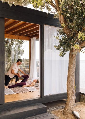 a man and woman laying on a bed in a house at White Exclusive Suites & Villas in Lagoa
