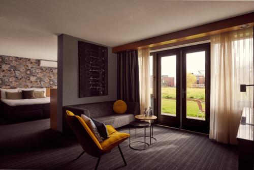 a hotel room with a couch and a bed at Van der Valk Drachten in Drachten