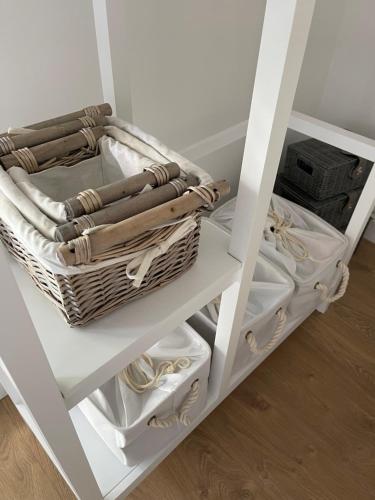 a white shelf with baskets and other items on it at Debussys Guest House in Saffron Walden
