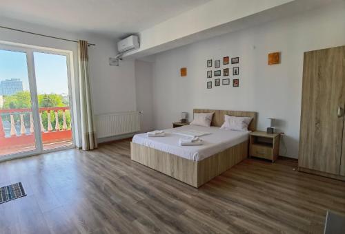 a bedroom with a large bed and a large window at Casa Tatiana Eforie Nord in Eforie Nord
