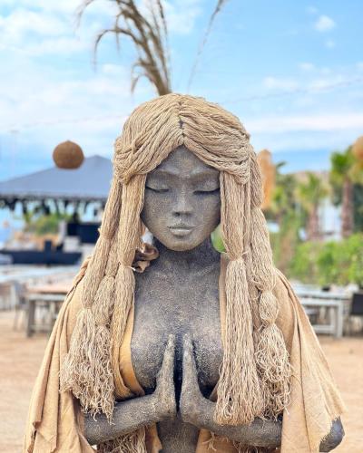 a statue of a woman doing yoga on the beach at Rammos Managed By Dedeman in Bodrum City