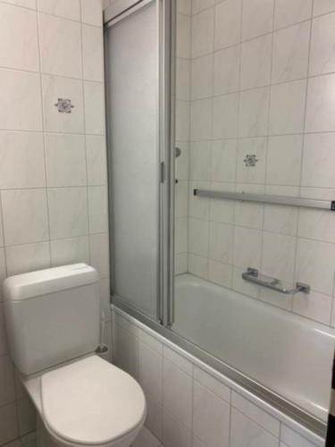 ein weißes Badezimmer mit Toilette und Dusche in der Unterkunft Paradies 04 in Arosa