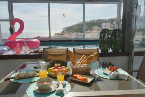 a breakfast table with a view of the water at Rooftop sea view with private swimming pool in Nazaré