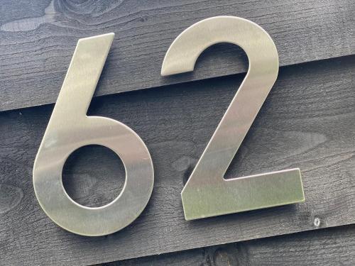 a large silver number on a wooden wall at PUUR Eernewoude luxe chalet direct aan open vaarwater gelegen in de Alde Feanen in Earnewâld