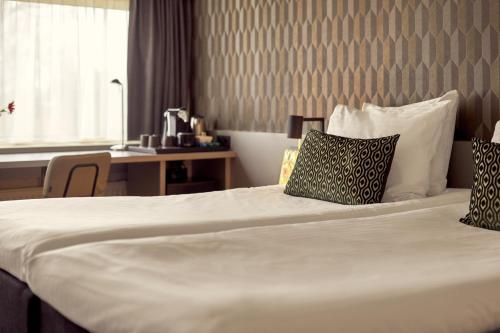 a hotel room with a bed with two pillows on it at Van der Valk Drachten in Drachten