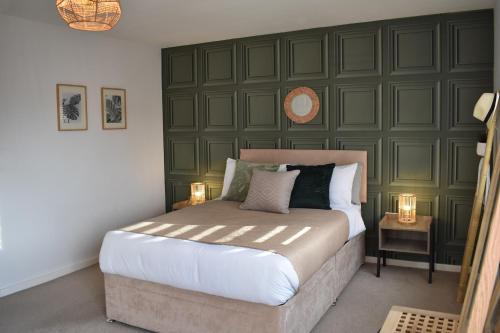 a bedroom with a large bed with a green wall at Maya Boutique Inn - Garden - Sleeps 6 in Wythenshawe