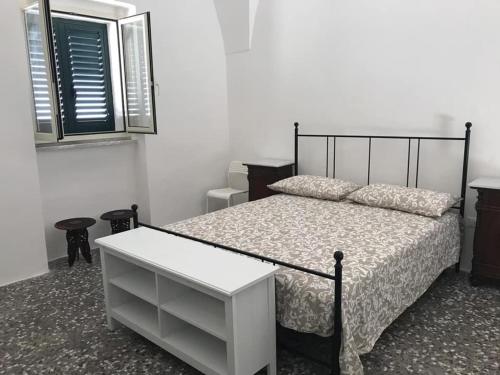 Schlafzimmer mit einem schwarzen und weißen Bett und einem Fenster in der Unterkunft SALENTO - Acquarica del Capo - Lecce in Acquarica del Capo