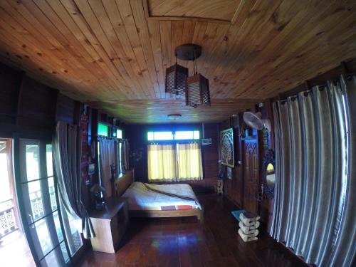 a bedroom with a bed and a wooden ceiling at Hello countryside in Ban Khang Hong Tai