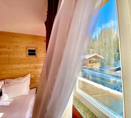 1 dormitorio con cama y ventana con vistas en Premium mountain view chalet, en Borşa