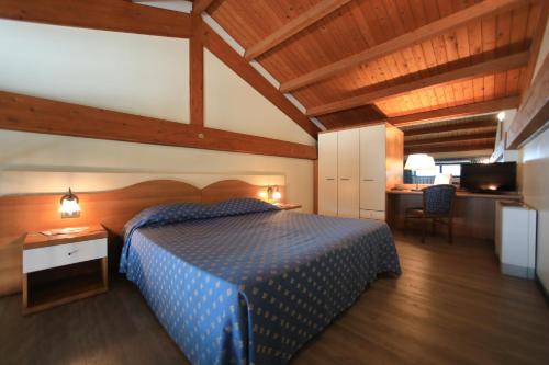 Hotel Eden في فاليجيو سول مينشيو: غرفة نوم بسرير ازرق ومكتب