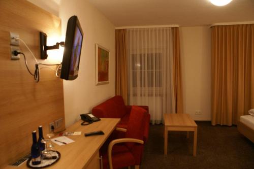 a hotel room with a desk and a living room at Haus Hennche in Siegen