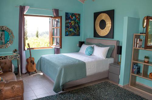 una camera con un letto e una finestra e una chitarra di The Little House Corfu ad Áno Korakiána
