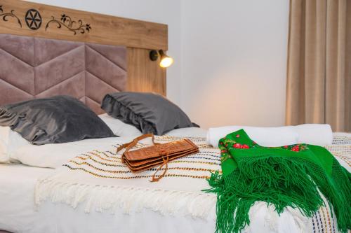 a bed with a green blanket and a purse on it at Maryna Bór in Zakopane