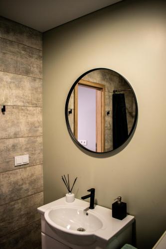 a bathroom with a sink and a mirror on the wall at Vila „Prie tvenkinio“ in Palanga
