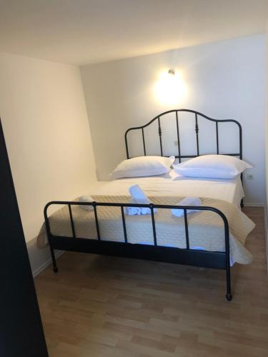 a bedroom with a bed with white sheets and pillows at Apartments Alać in Drasnice