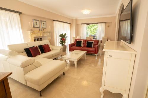 a living room with white furniture and a red couch at Il Castellaccio in Spello