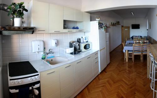 a kitchen with white cabinets and a sink and a table at Gile Guest House in Veliko Tŭrnovo