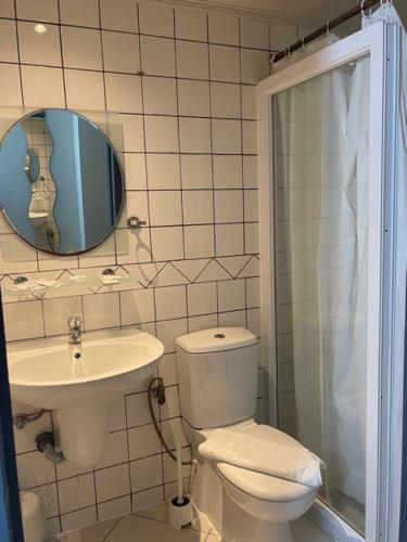 a bathroom with a toilet and a sink and a mirror at Hotel Bentley New in Brussels