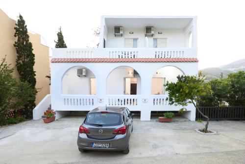 a car parked in front of a white house at Afroditi Hotel in Plakias