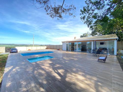 a house with a patio and a swimming pool at Chácara Toledo Costa in Itapeva