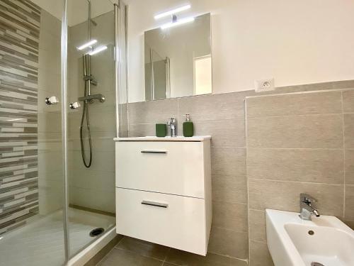 une salle de bain blanche avec un lavabo et une douche dans l'établissement Montée fleurie, à Menton