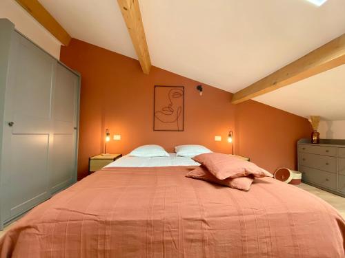 une chambre avec un grand lit aux murs orange dans l'établissement Montée fleurie, à Menton