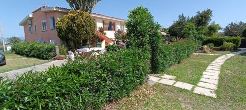 a house with trees and bushes in a yard at Orosei RE - Villa Aurora Rimedia a 50 metri dal mare in Orosei