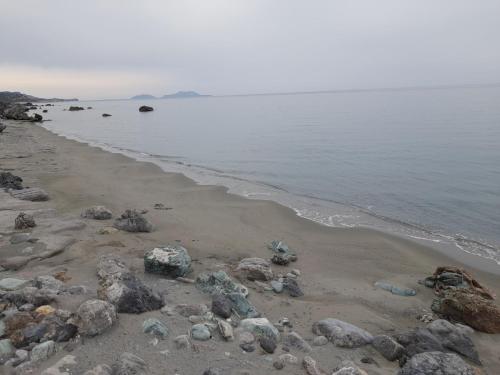 a beach with rocks and the water at VILLA SISSY in Agia Paraskevi
