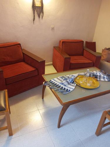a living room with chairs and a table with a plate on it at VILLA SISSY in Agia Paraskevi