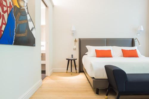 a bedroom with a bed with orange pillows at Villas Foch Boutique Hotel & Spa Bordeaux in Bordeaux